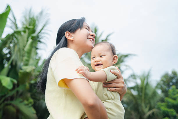 istock Adult Carrying Baby Outdoors in Bright Environment 2249548566