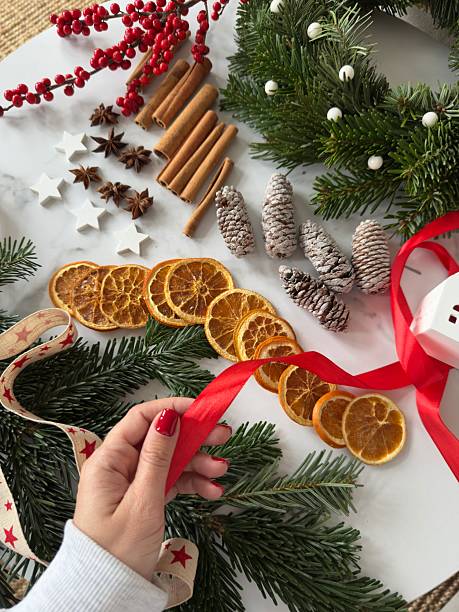 POV of woman's hand holding ribbon preparing DIY Christmas wreath