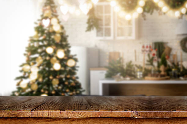 istock Wooden table with blurred Christmas tree and fireplace background 2249548956
