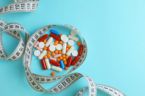 istock centimeter tape and pills on a colored background with space for text. concept of losing weight, diet, fat burning, healthy eating. minimalism. 2249550105