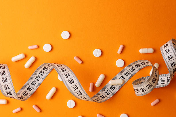 istock centimeter tape and pills on a colored background with space for text. concept of losing weight, diet, fat burning, healthy eating. minimalism. 2249550119