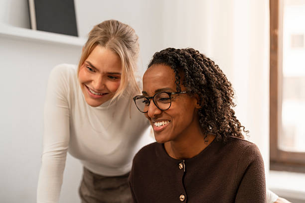 istock Two smiling women collaborate at a bright desk, sharing ideas and enjoying teamwork 2249550983