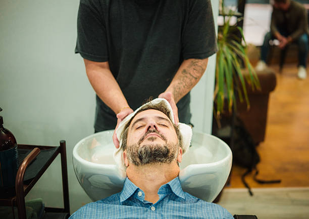 Adult man enjoying a professional hair wash and head massage at a modern barbershop
