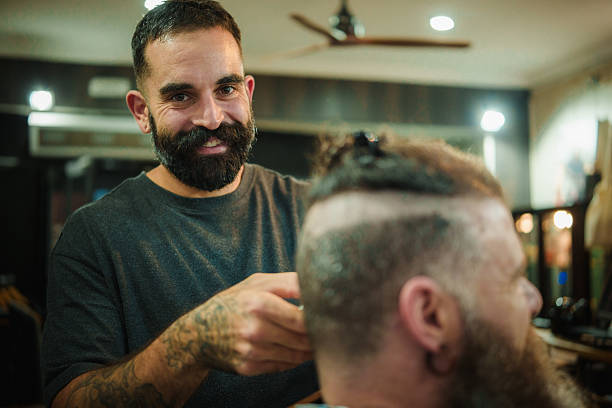 istock Barber smiling while giving customer a haircut 2249551785