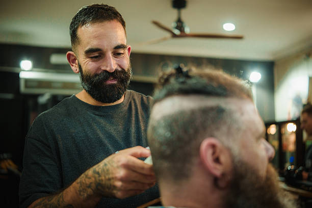 istock Barber giving client haircut in barbershop 2249551846