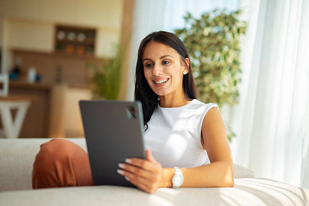istock Woman smiling having video call at home on sofa 2249554665