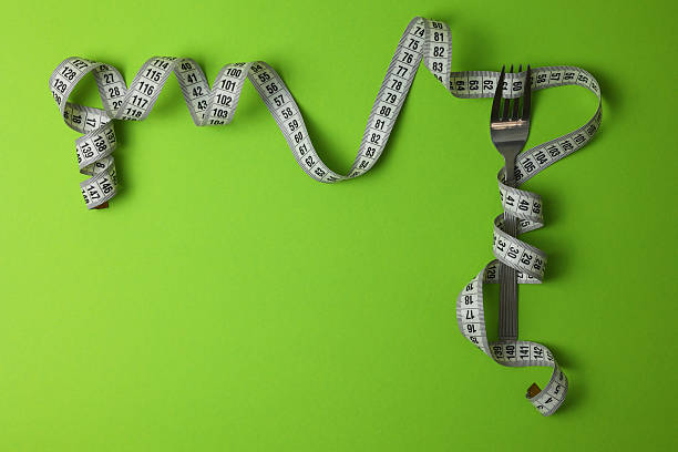 istock A Fresh Green Apple Placed Alongside a Measuring Tape Set Against an Aqua Background 2249555476