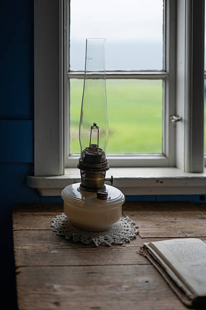 kerosene lamp against window in room