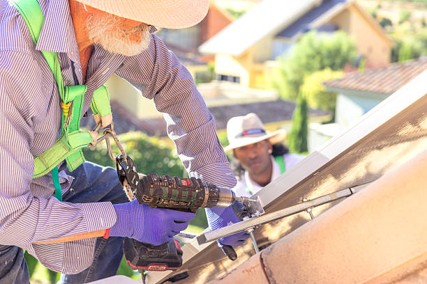 istock Installers working on solar panel installation on house roof 2249562956