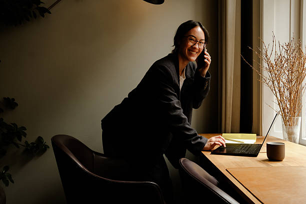 istock Asian Businesswoman Using Smartphone in Modern Workspace – Natural Light Portrait 2249564155