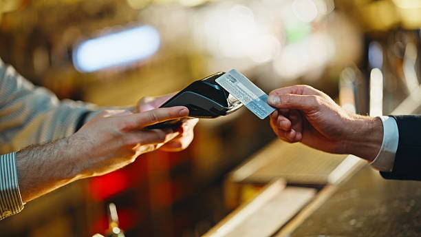 istock Unknown man paying bill with credit card in evening restaurant counter closeup 2249566915