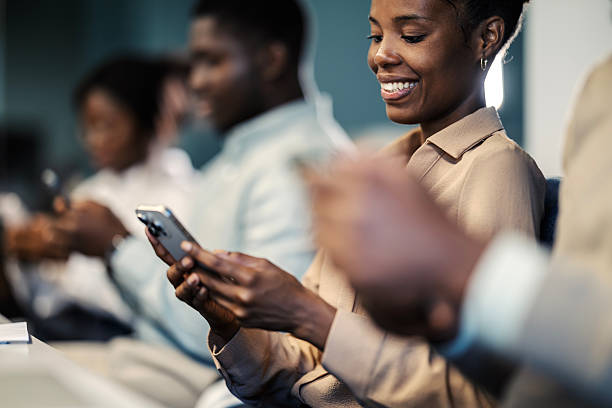 istock Diverse business professionals smiling, using smartphones in office meeting 2249566933