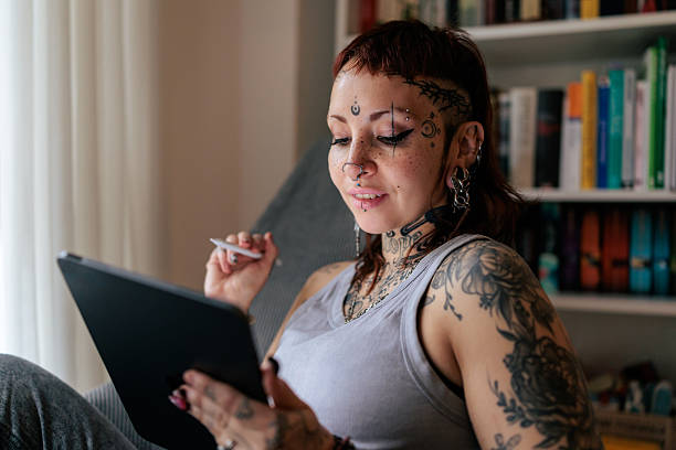 istock Tattoo Artist Using a Digital Tablet to Create Designs 2249570050