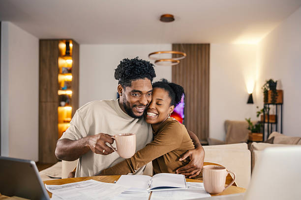istock Happy black couple hugging while reviewing home finances 2249572269