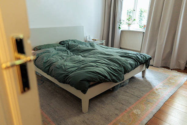 istock Cozy Bedroom With Dark Green Bedding 2249573264