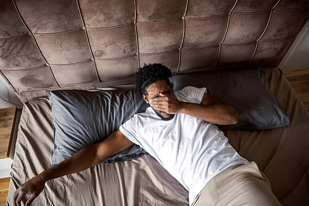 istock Man waking up in bed feeling tired and stressed 2249573777