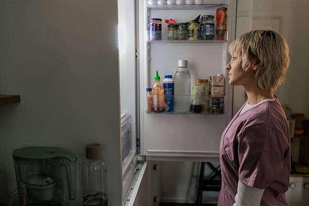 istock Nurse Looking Inside the Refrigerator in a Staff Kitchen 2249575485
