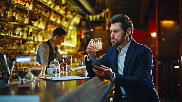 istock Lonely man drinking alcohol at bar counter closeup. Upset guy browsing phone 2249578044