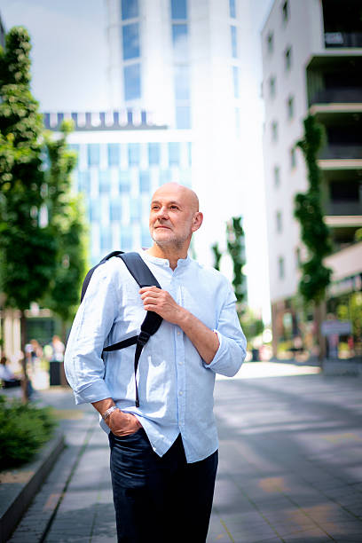 istock Confident middle aged man walking along a city street and sightseeing 2249578103