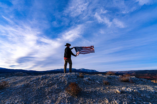 istock Cowboy on Ridge with American Flag 2249578330