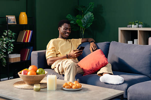 istock Young man relaxing on couch browsing smartphone 2249579068
