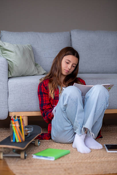 istock Teenager girl studying homework while sitting on rug 2249580508