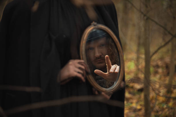 In a dense forest filled with autumn leaves, a cloaked figure gazes into a mirror. The scene feels eerie as the figure's hand reaches toward the reflective surface, creating a sense of intrigue.