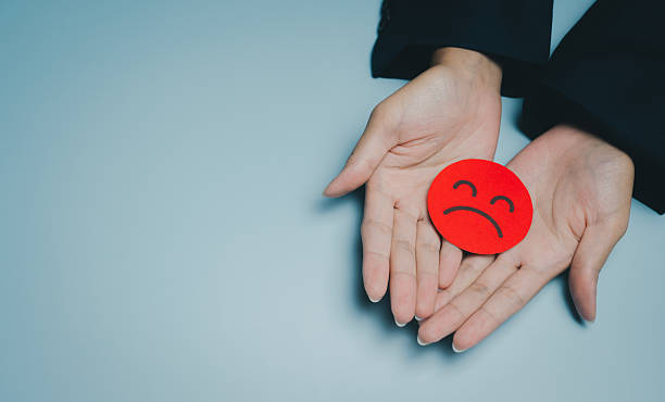 istock Sad face icon, hands holding, emotion, feeling, expression, isolated on blue background, concept of sadness or disappointment 2249586505
