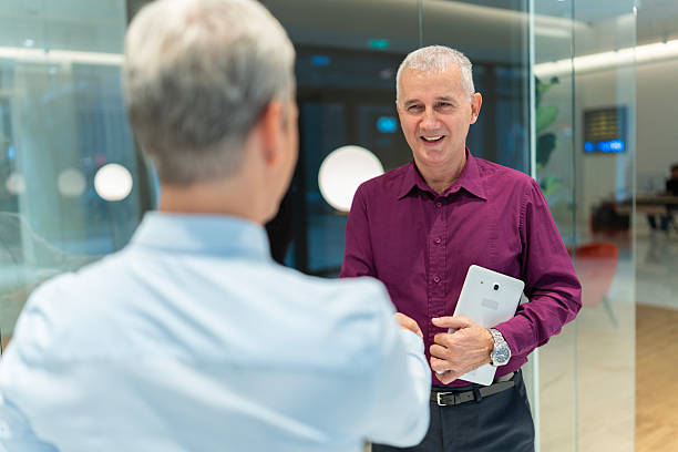 istock Senior business professional shaking hands in modern office 2249586683