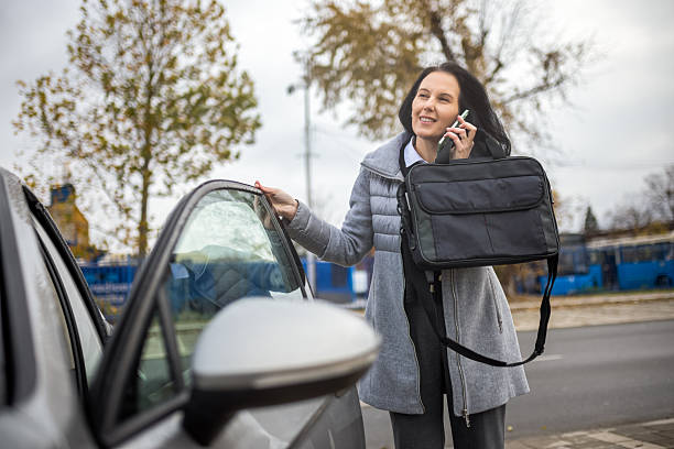 istock Woman opening car door while on phone with laptop 2249590848