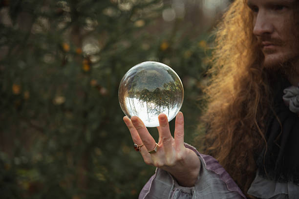 istock Person holds clear crystal ball while standing amidst trees in autumn light 2249591168