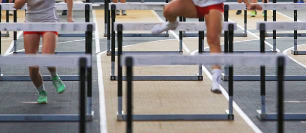 istock Two Athletes Competing in Hurdle Race on an Indoor Track 2249592670