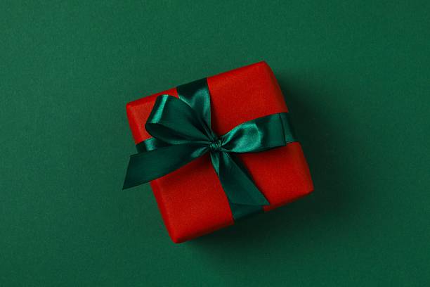 istock Beautiful Christmas gift with satin bow on green background 2249606638