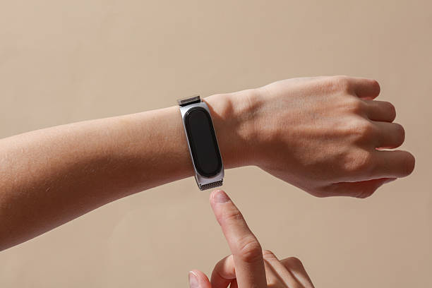 istock Female hand with modern smart bracelet on wrist, beige background 2249607447