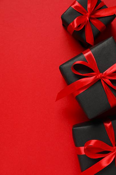 istock Vertical view of gift boxes tied with bow on red background 2249610247