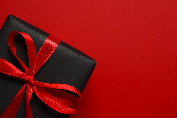 istock Festive gift tied with bow on red background 2249610334