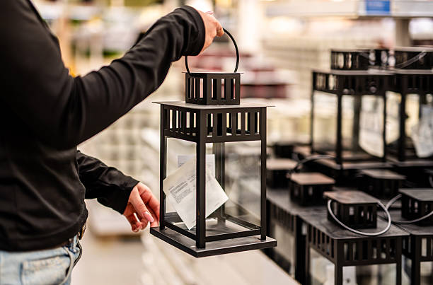 Close-Up Of A Woman Picking A Decorative Candle Lantern At A Store