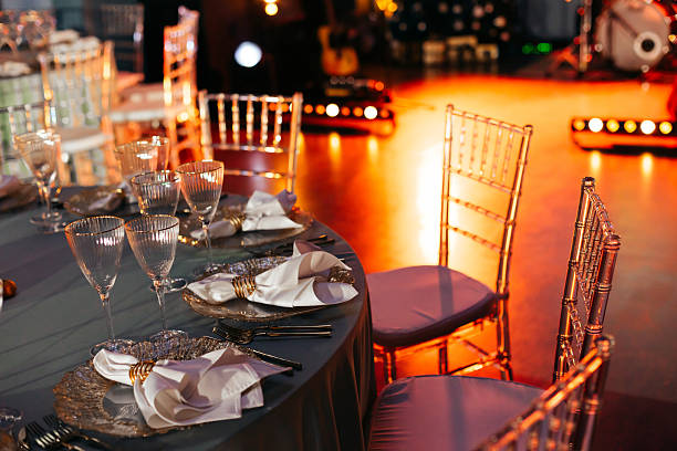 istock Elegantly set banquet table with gold chargers and ambient stage lighting 2249614564