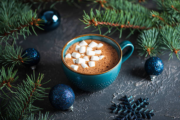 istock Hot Chocolate with Marshmallows in Teal Mug Surrounded by Christmas Decor 2249614955