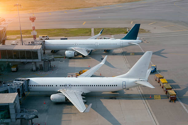 istock Two passenger planes connected by a jet bridge undergo maintenance after the aircraft's arrival at a large aviation hub. 2249615260