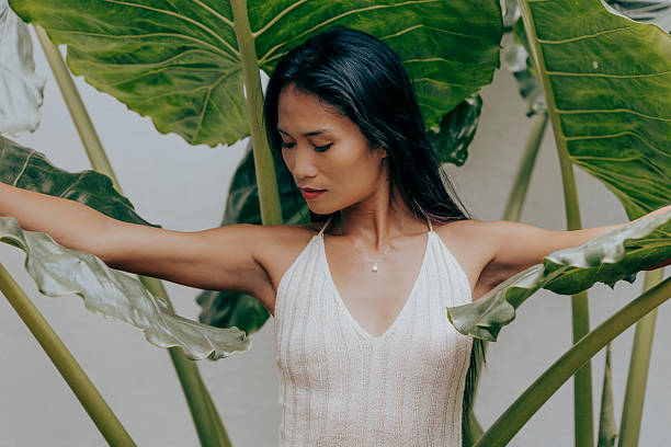 istock Woman looking down with arms extended in leafy environment 2249615610