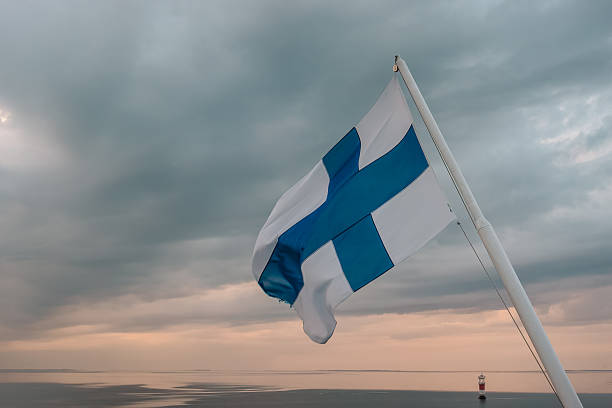 istock Finnish flag waving over Baltic Sea at sunset 2249617044