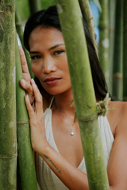 istock Woman surrounded by bamboo looking softly into the distance 2249617308