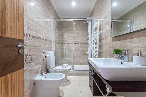 istock A stylish bathroom featuring a glass shower, modern sink, and sleek tiles. Soft lighting creates a calming atmosphere in this well-designed space 2249622362