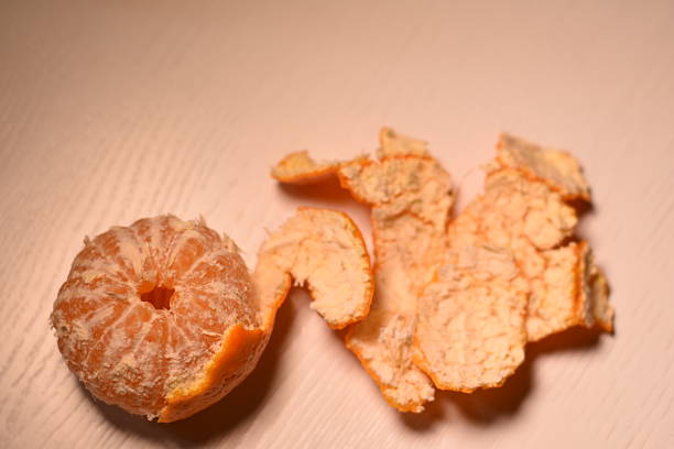 istock Horizontal top view of almost peeled mandarin with peel 2249624762