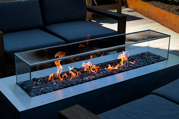 istock Outdoor fireplace with glass sides and smooth stones 2249625500