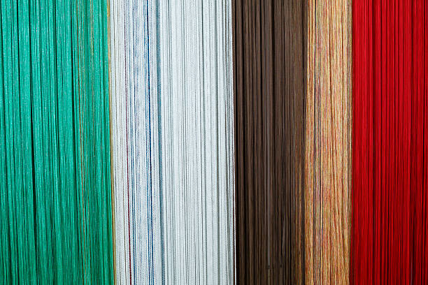 Curtain samples hanging from hangers on rail in store. Fabric texture samples selection fabrics for interior decoration Curtains, tulle and furniture upholstery.