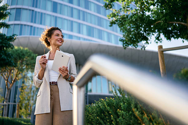 istock Confident businesswoman smiling while holding digital tablet outside office 2249631585