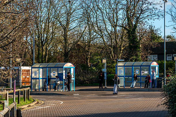 Cambridge, UK - November 28, 2025: People waiting at bus stops at a bus station on a bright, sunny winter day