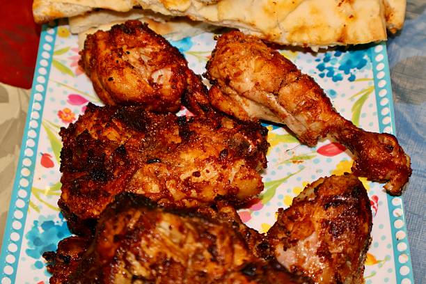 istock Chicken BBQ, a tray filled with freshly grilled pieces with naan bread beside. 2249637637
